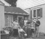 Black and White photo of Bosnian family outside a home.